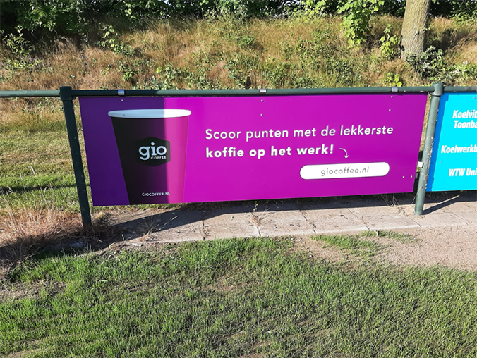 Gio Coffee sponsorbord bij een sportclub