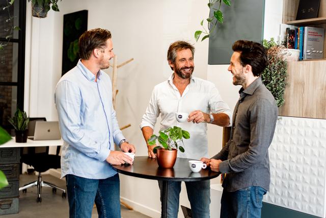 Collega's drinken koffie op het werk van Gio Coffee